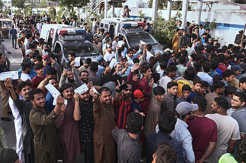 Fans stand in queues and wait for the opening of the National Stadium for the Pakistan Super League Qualifier cricket match between Peshawar Zalmi and Islamabad United, in Karachi, Pakistan, Tuesday, April 28, 2026. 