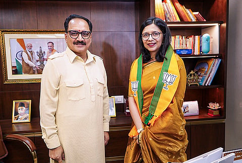 Delhi BJP president Virendra Sachdeva, left, poses for photographs with MP Swati Maliwal during her visit to state party office after joining the party, in New Delhi. 
