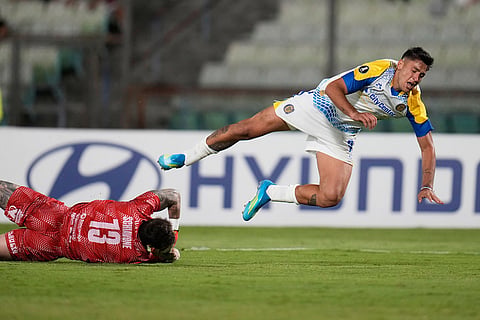 Goalkeeper Giancarlo Schiavone of Venezuela's Universidad Central, left, fouls inside the penalty area Alejo Veliz of Argentina's Rosario Central during a Copa Libertadores Group H soccer match in Caracas, Venezuela.