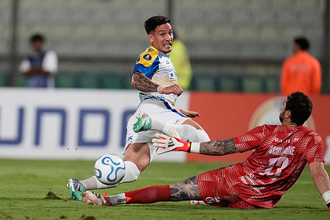 Enzo Copetti of Argentina's Rosario Central, left, scores his side's third goal against Venezuela's Universidad Central during a Copa Libertadores Group H soccer match in Caracas, Venezuela.