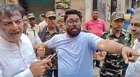 Security personnel detains a man after a clash erupted due to a glitch in EVM causing the voting to be delayed during the second and final phase of the West Bengal Assembly elections, at Bally, in Howrah district.