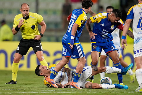 Angel Di Maria of Argentina's Rosario Central, bottom, is challenged by Yohan Cumana of Venezuela's Universidad Central (24) during a Copa Libertadores Group H soccer match in Caracas, Venezuela.