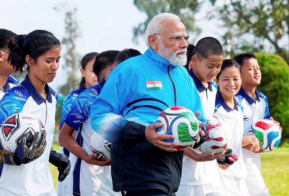 Prime Minister Narendra Modi with young footballers during his visit to Sikkim, in Gangtok.  - | Photo: @narendramodi/X via PTI