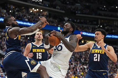 Minnesota Timberwolves forward Julius Randle, third from left, pulls in a loose ball as, from left, Denver Nuggets guard Tim Hardaway Jr., center Nikola Jokic and forward Spencer Jones defend in the second half in Game 5 of a first-round NBA playoffs basketball series in Denver.