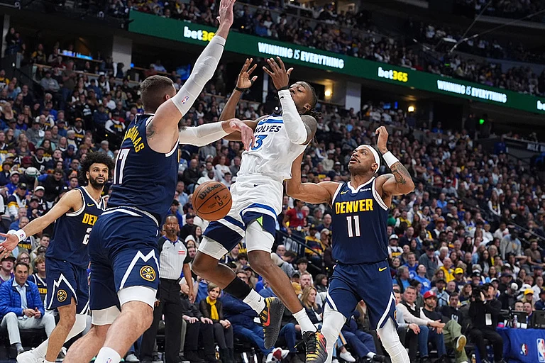Minnesota Timberwolves guard Ayo Dosunmu, center, loses control of the ball while driving to the net between Denver Nuggets center Jonas Valanciunas, left, and guard Bruce Brown in the second half in Game 5 of a first-round NBA playoffs basketball series in Denver. - | Photo: AP/David Zalubowski