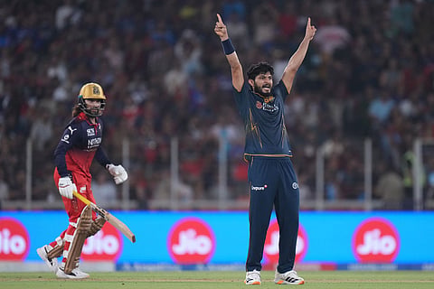 Gujarat Titans' Arshad Khan celebrates the wicket of Royal Challengers Bengaluru's captain Rajat Patidar during the Indian Premier League cricket match between Gujarat Titans and Royal Challengers Bengaluru in Ahmedabad, India.