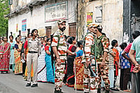Maach, Muri, Manush: Theatrics Of Bengal Election | Photo: Sandipan Chatterjee : Guns and Forces: Voters line up to cast their vote in the second phase of the West Bengal election amid heavy security