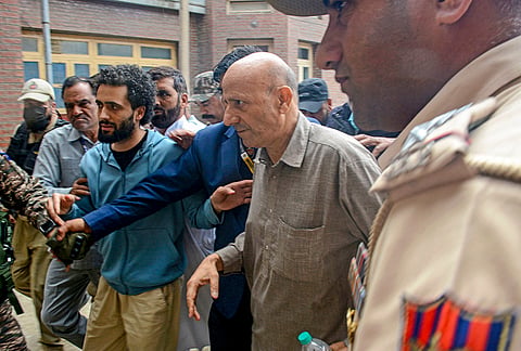 Jailed Lok Sabha member Sheikh Abdul Rashid being escorted by security personnel as he arrives to meet his ailing father after the Delhi High Court granted him a week's interim bail, at SMHS hospital in Srinagar.