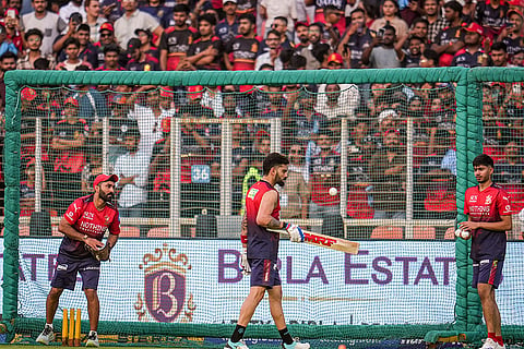 Royal Challengers Bengaluru’s Virat Kohli, centre, with team's Mentor and Batting Coach Dinesh Karthik, left, during a warm-up session before an Indian Premier League (IPL) 2026 T20 cricket match between Gujarat Titans and Royal Challengers Bengaluru, in Ahmedabad, Gujarat.