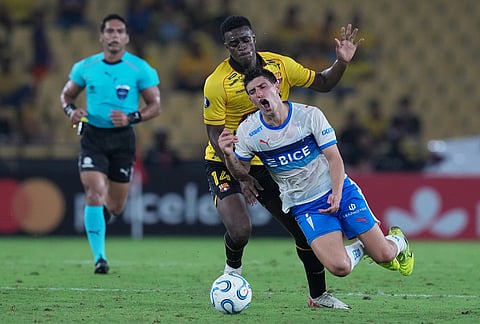 Justo Giani of Chile's Universidad Catolica, right, is fouled by Alex Rangel of Ecuador's Barcelona during a Copa Libertadores Group D soccer match in Guayaquil, Ecuador.