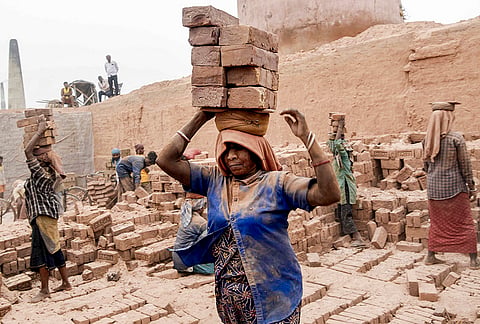 Labourers carry bricks at a brick factory, on the eve of Labour Day, also known as May Day, in Patna, Bihar.