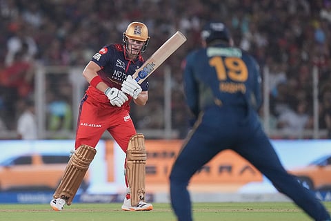 Royal Challengers Bengaluru's Jacob Bethell looks at Gujarat Titans' Rashid Khan takes a catch to dismiss him during the Indian Premier League cricket match between Gujarat Titans and Royal Challengers Bengaluru in Ahmedabad, India.