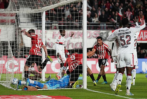 Guido Carrillo of Argentina's Estudiantes de La Plata, center, scores his side's opening goal against Brazil's Flamengo during a Copa Libertadores Group A soccer match in La Plata, Argentina.