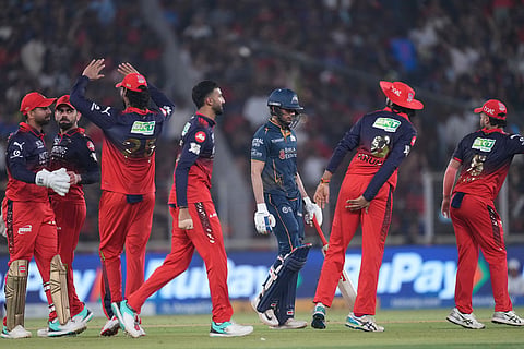 Royal Challengers Bengaluru's players celebrate the wicket of Gujarat Titans' captain Shubman Gill during the Indian Premier League cricket match between Gujarat Titans and Royal Challengers Bengaluru in Ahmedabad, India.