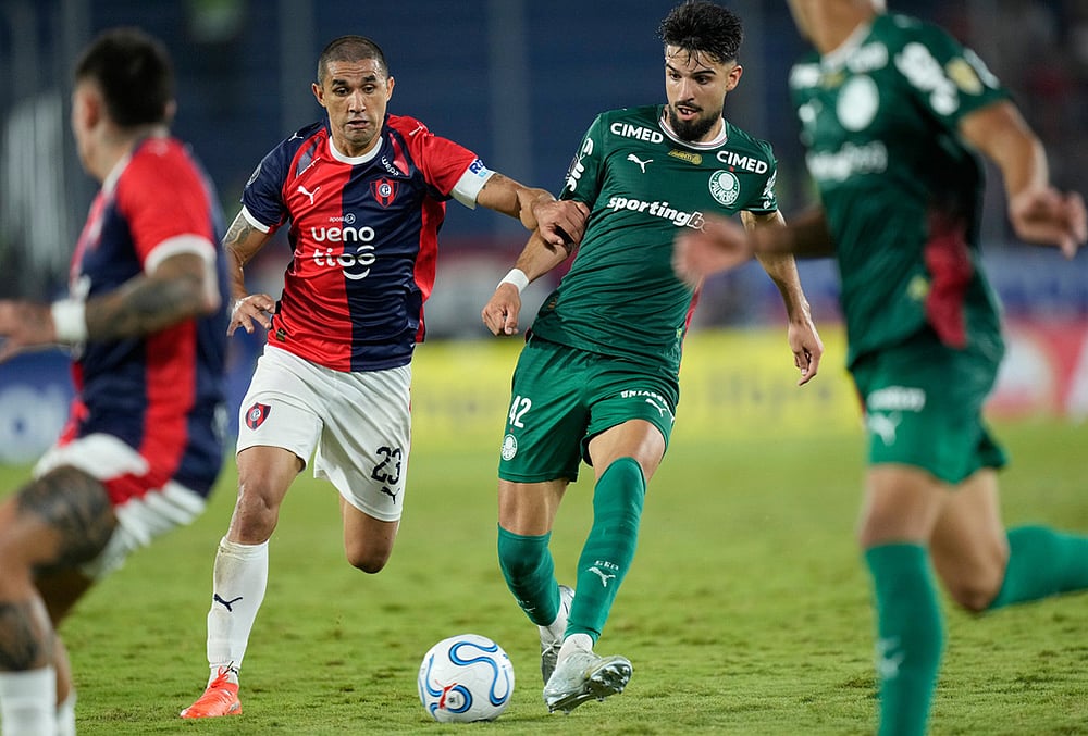 Flaco Lopez of Brazil's Palmeiras, center right, and Victor Velazquez of Paraguay's Cerro Porteno battle for the ball during a Copa Libertadores Group F soccer match in Asuncion, Paraguay. - | Photo: AP/Jorge Saenz