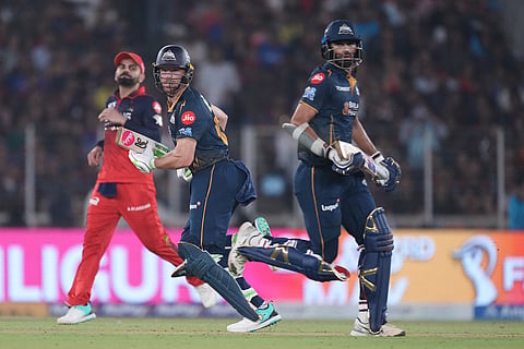 Gujarat Titans' Washington Sundar, right, and Jos Buttler run between the wickets during the Indian Premier League cricket match between Gujarat Titans and Royal Challengers Bengaluru in Ahmedabad, India.