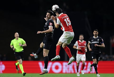 Freiburg's Igor Matanovic jumps for the ball with Braga's Paulo Oliveira during the Europa League semifinal, first leg, soccer match between SC Braga and Freiburg in Braga, Portugal.