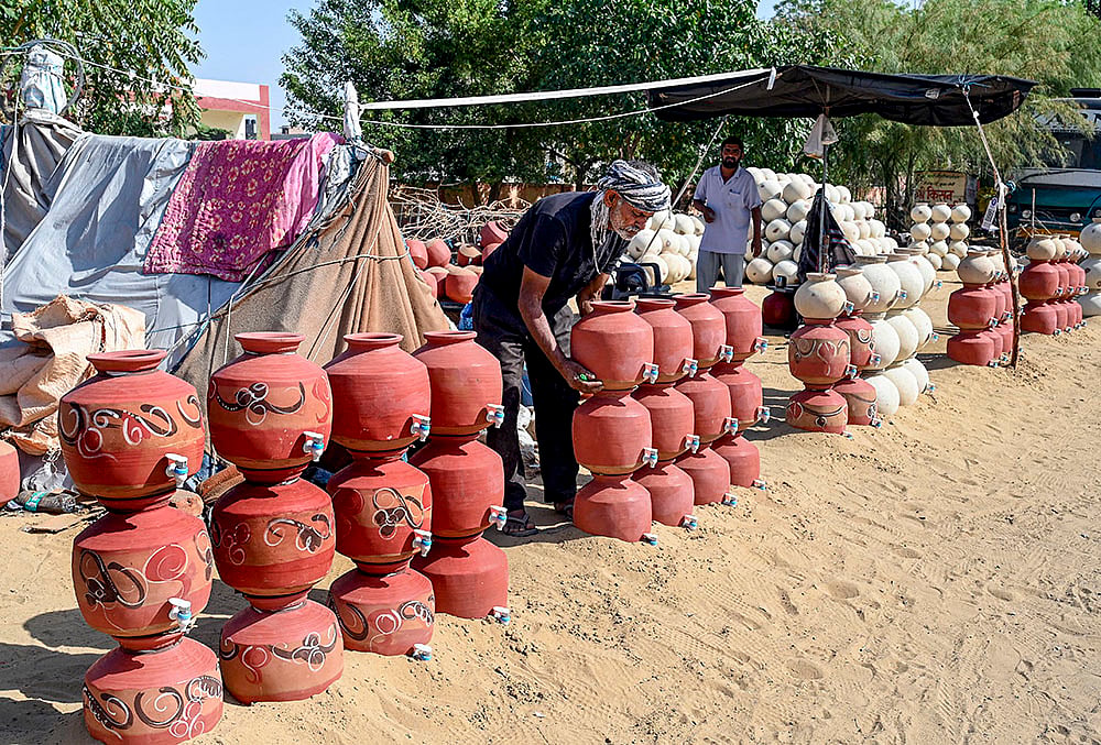 | Photo: PTI : A vendor arranges clay pots for sale on a hot summer day, in Bikaner, Rajasthan.