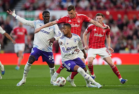 Aston Villa's Ezri Konsa, centre left, and Nottingham Forest's Chris Wood battle for the ball during the Europa League semifinal first leg soccer match between Nottingham Forest and Aston Villa in Nottingham, England.