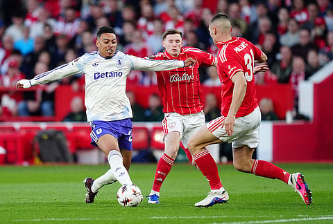 Aston Villa's Morgan Rogers, left, challenges for the ball with Nottingham Forest's Elliot Anderson, centre, and Nikola Milenkovic during the Europa League semifinal first leg soccer match between Nottingham Forest and Aston Villa in Nottingham, England.