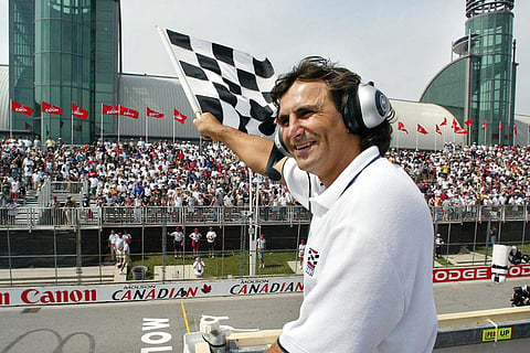 Former CART champion driver Alex Zanardi waves the checkered flag at the finish line at the CART Molson Indy, in Toronto.