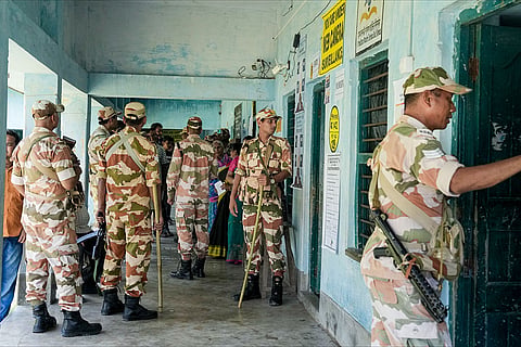 Security personnel stand guard at a polling station during a repoll ordered by the Election Commission following reports of electoral malpractices, at Magrahat Paschim constituency, in South 24 Parganas district, West Bengal.