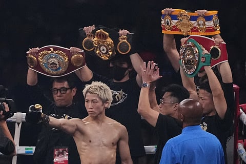 Naoya Inoue of Japan poses with his champion belts before a boxing match against Junto Nakatani of Japan for the WBA, WBC, IBF and WBO super bantamweight world title in Tokyo, Saturday, May 2, 2026.