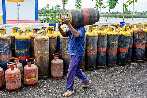 A worker stacks up a commercial LPG cylinder amid the ongoing supply crisis, in Malda, West Bengal. A 19-kg commercial LPG cylinder has been hiked by a record Rs 993, marking the third consecutive monthly hike as global energy prices continue to surge.