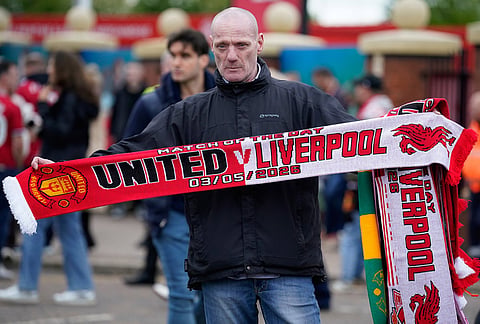 A soccer fan poses for a photo ahead of the English Premier League soccer match between Manchester United and Liverpool in Manchester, England.