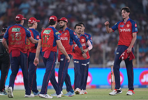 Punjab Kings' Marco Jansen, right, celebrates the wicket of Gujarat Titans' Rahul Tewatia with others during the Indian Premier League cricket match between Gujarat Titans and Punjab Kings in Ahmedabad.