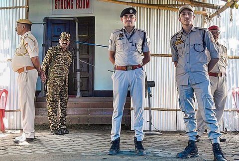 Security personnel of Assam Police stand guard outside a strong room storing EVMs on the eve of counting of votes for the Assam Assembly elections, in Tezpur, Sonitpur district.