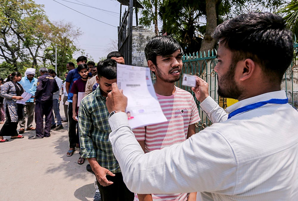 Aspirants undergo security check before appearing for the National Eligibility-cum-Entrance Test (NEET-UG) examination, in Prayagraj, Uttar Pradesh. - | Photo: PTI