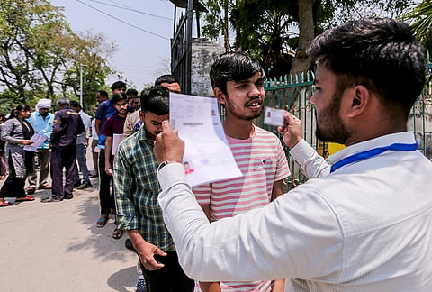 Aspirants undergo security check before appearing for the National Eligibility-cum-Entrance Test (NEET-UG) examination, in Prayagraj, Uttar Pradesh.
