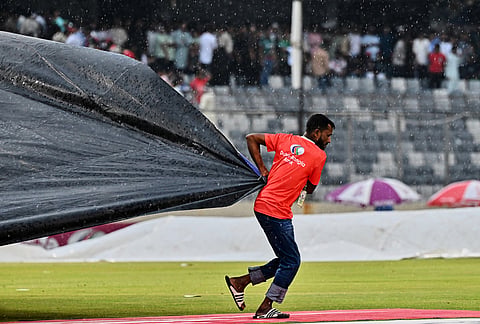 A groundsman coveres the pitch after rain stoped the play during the third T20 international cricket match between Bangladesh and New Zealand in Mirpur, Bangladesh.