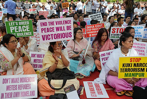 People hold placards during a protest on the third anniversary of the Manipur violence, at Jantar Mantar, in New Delhi.