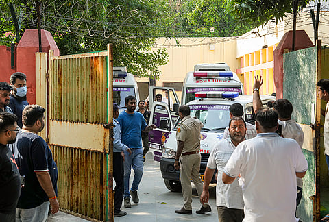 Family members and relatives of victims killed in a fire at a residential building wait outside the mortuary of GTB Hospital to receive the bodies after post-mortem, in New Delhi.