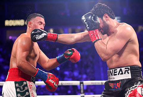 Gilberto Ramirez punches David Benavidez in a cruiserweight championship boxing match in Las Vegas.