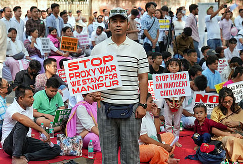 People hold placards during a protest on the third anniversary of the Manipur violence, at Jantar Mantar, in New Delhi.