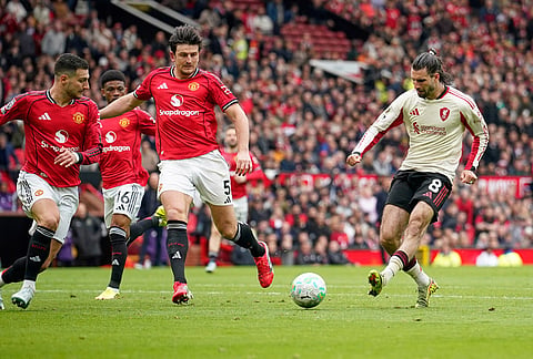Liverpool's Dominik Szoboszlai, right, scores his side's opening goal during the English Premier League soccer match between Manchester United and Liverpool in Manchester, England.