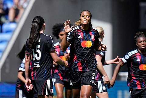 Lyonnes' Wendie Renard, center, celebrates after scoring the opening goal from the penalty spot during the Women's Champions League semifinal, second leg, soccer match between OL Lyonnes and Arsenal, in Decines, outside Lyon, France.