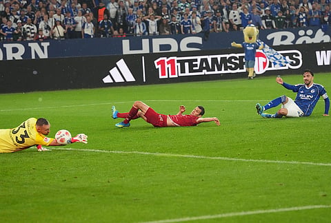 Duesseldorf's goalkeeper Florian Kastenmeier, left, makes a save in front of Schalke's Kenan Karaman, right, during the German Bundesliga 2 soccer match between FC Schalke 04 and Fortuna Duesseldorf in Gelsenkirchen, Germany.