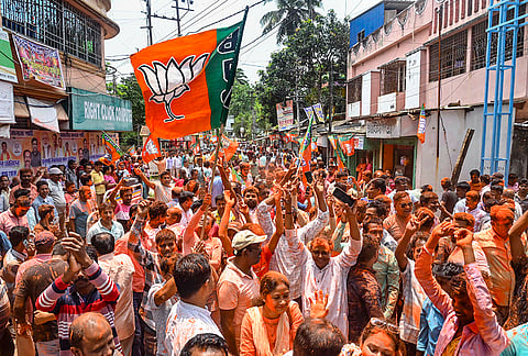 BJP workers celebrate as the party takes an early lead during the West Bengal Assembly elections result day, at Balurghat, in Dakshin Dinajpur district.