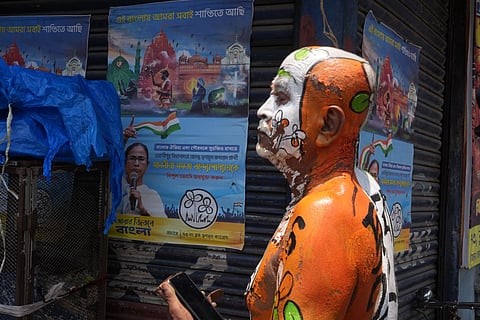 A Trinamool Congress supporter with party symbols painted on his body reacts as he watches election updates on the day of Assembly election results, in Kolkata.