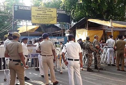 Security personnel and officials outside a vote counting centre during the West Bengal Assembly election results day, in Kolkata.