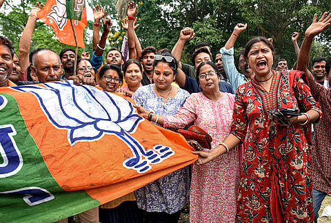 BJP supporters celebrate the party's lead during vote tabulation on the day of Assembly election results, in Kolkata.