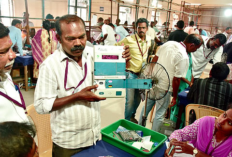 An election official demonstrates an electronic voting machine (EVM) during vote counting at a counting centre, in Madurai, Tamil Nadu.