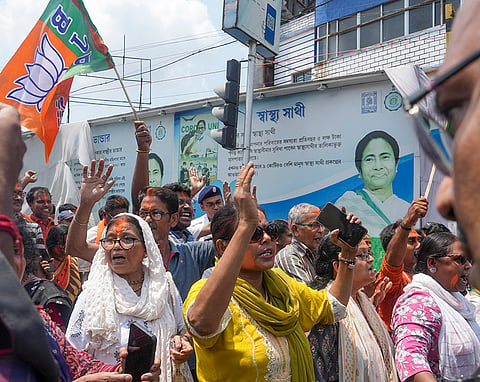BJP supporters shout slogans as they pass by the residence of West Bengal Chief Minister Mamata Banerjee during vote tabulation on the day of Assembly election results, in Kolkata.