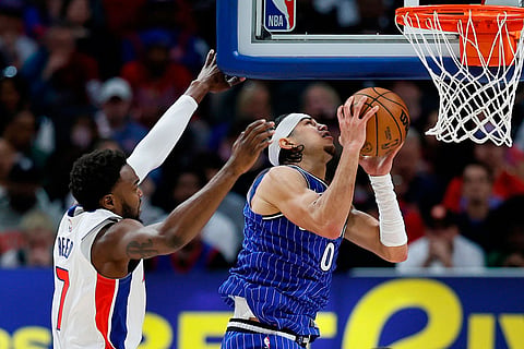 Orlando Magic guard Anthony Black (0) goes to the basket past Detroit Pistons forward Paul Reed (7) during the first half in Game 7 of a first-round NBA basketball playoffs series in Detroit.