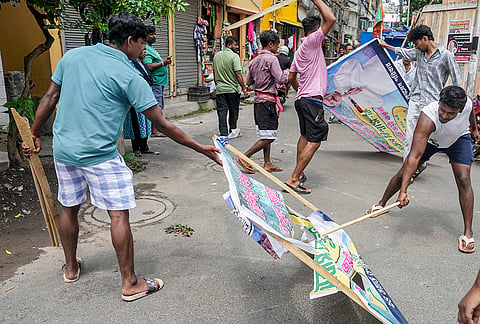 BJP supporters remove TMC hoardings from the streets of Tollyganj constituency after BJP wins the West Bengal Assembly elections, in Kolkata.