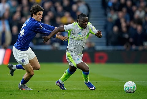 Everton's Merlin Roehl, left, and Manchester City's Jeremy Doku fight for the ball during the Premier League soccer match between Manchester City and Everton in Liverpool, England.